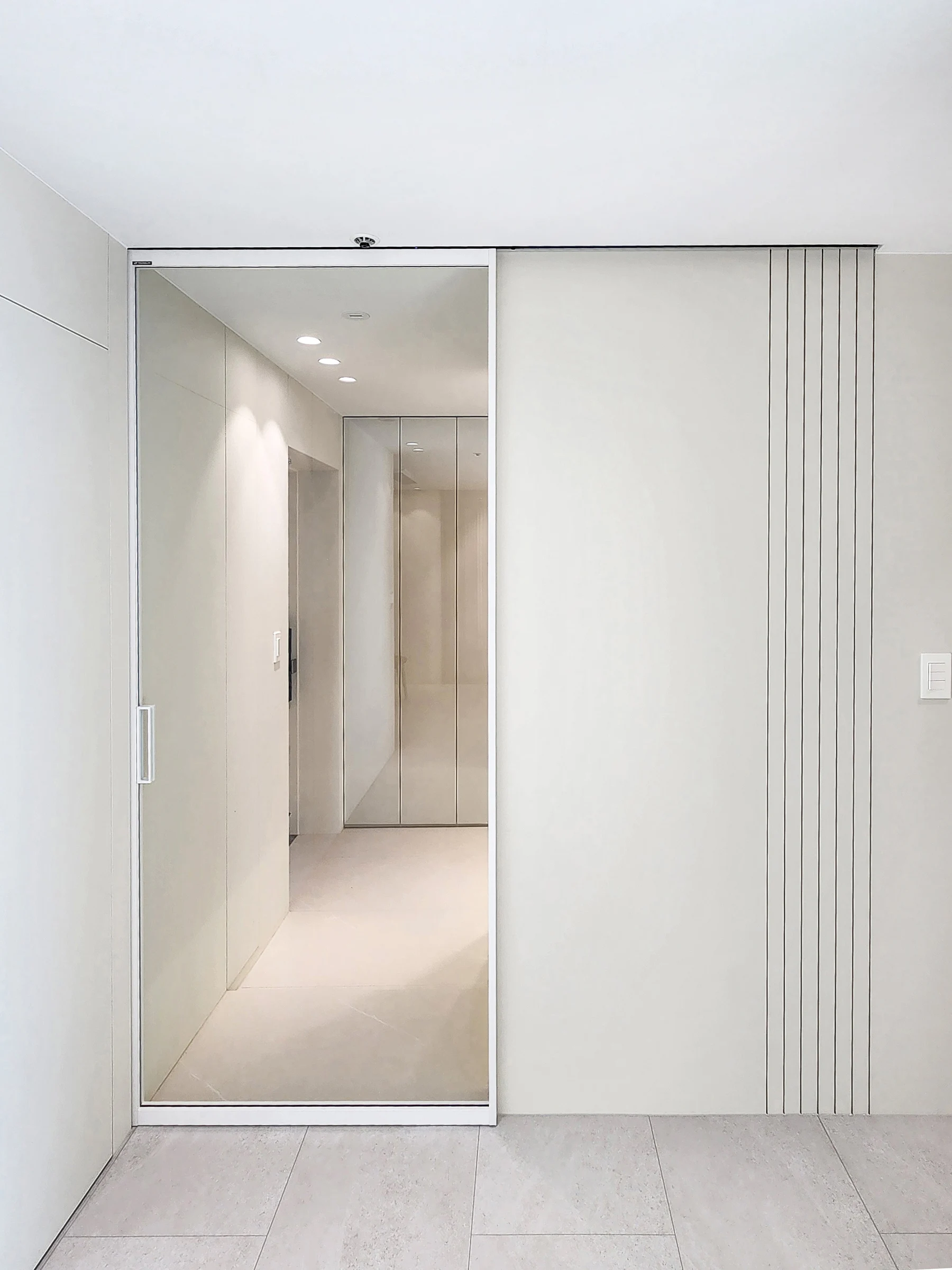 거울과 세로 라인으로 정돈한 현관 벽면